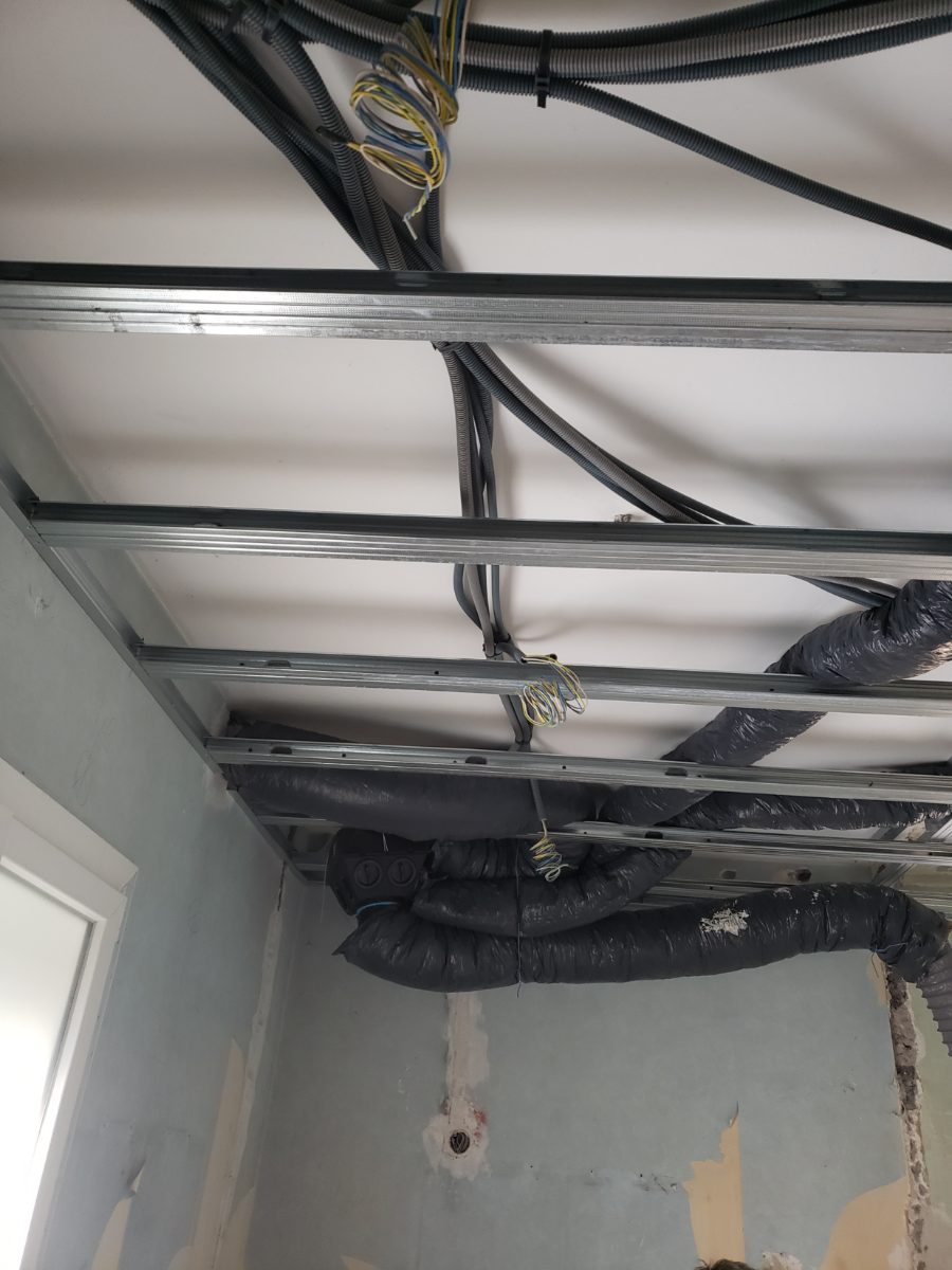 Plafond en cours de câblage : rails, gaines électriques et gaines de VMC, avant fermeture.
